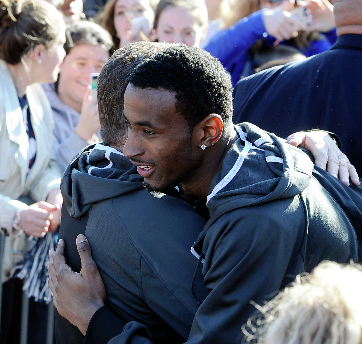Connecticut men's basketball player DeAndre Daniels, right, hugs Connecticut women's head coach Geno Auriemma after Auriemma arrived on campus with his team for a rally celebrating their NCAA title on Wednesday, April 9, 2014, in Storrs, Conn.