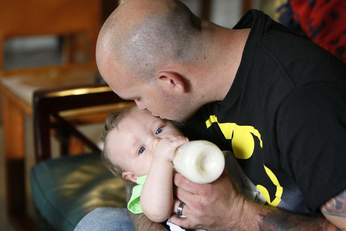 Mike Moore, 30, kisses his son Memphis, 6 months old, while feeding him in his hotel room on April 11, 2014 in Palo Alto, Calif. Moore had his penis reconstructed in 2007 after he lost his in a circumcision accident when he was 7 and was able to naturally conceive a son with his wife, believed by Moore's doctor to be the first time this has happened.