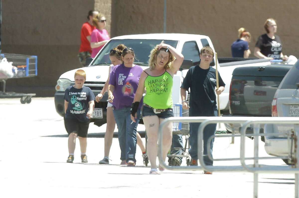 Customers leave the Wal-Mart shopping center after being kept inside for four hours while FBI bomb squad and Kemah police investigated a suspicious device in the parking lot on Saturday, April 19, 2014, in Kemah. ( J. Patric Schneider / For the Chronicle )