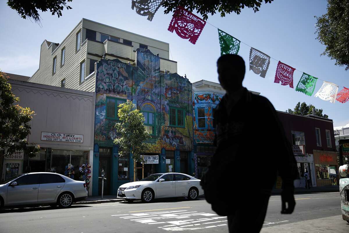 Condos (second from left) are seen behind a facade that was saved along with the mural on it along 24th Street on Thursday, April 17, 2014 in San Francisco, Calif.
