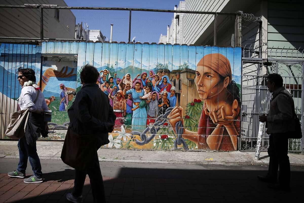 Erick Arguello (right), president of Calle 24, admires murals while walking on Balmy Alley along with other pedestrians on Thursday, April 17, 2014 in San Francisco. 