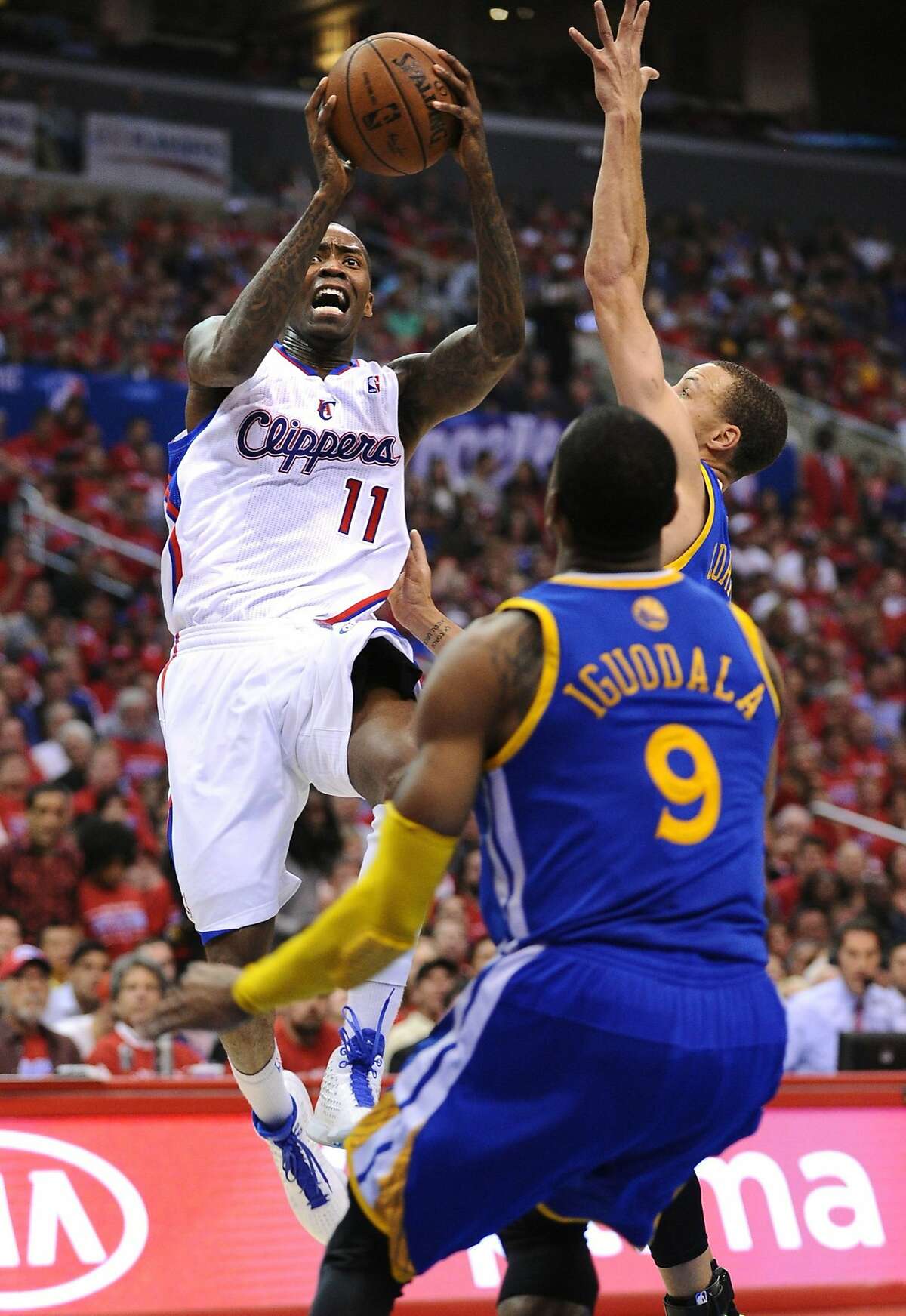 The Los Angeles Clippers' Jamal Crawford (11) drives to the basket against Golden State Warriors defenders Stephen Curry and Andre Iguodala (9) during Game 2 of the NBA Western Conference quarterfinals at the Staples Center in Los Angeles, Monday, April 21, 2014. (Wally Skalij/Los Angeles Times/MCT)