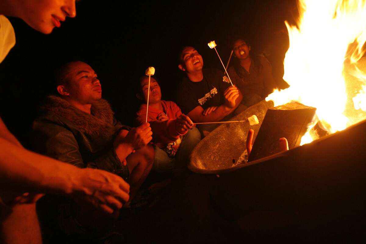Brendan Espinoza of Pacifica (l to r), Bryan Ramirez of So. San Francisco, Louise Jabagat of San Francisco, Randy Sullins of So. San Francisco and an unidentified young lady enjoyed the day's good weather in San Francisco, Calif. into the night on Ocean Beach in San Francisco, Calif. as they roasted hot dogs and marshmallows at a fire on the beach on Thursday August 28, 2008.