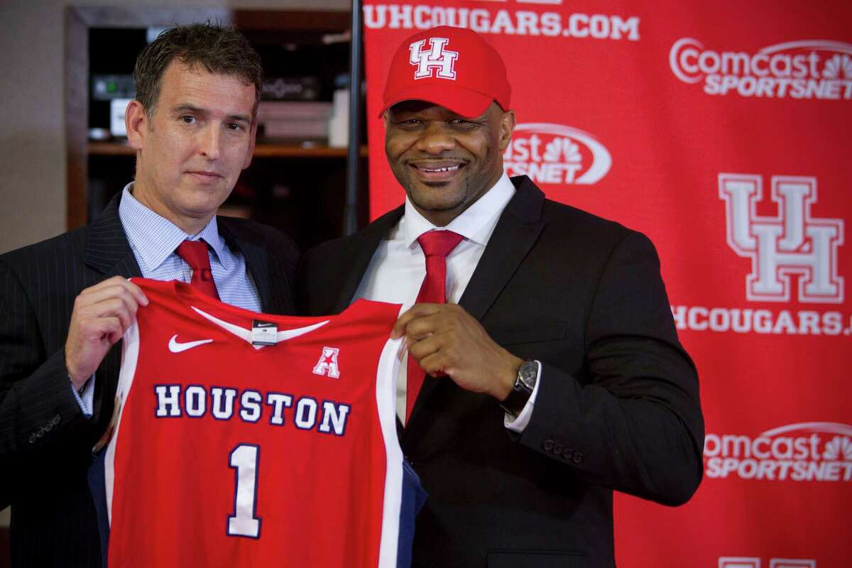Mack Rhoades, vice president for Intercollegiate Athletics at the University of Houston, left, poses for photos with Ronald Hughey as Hughey is introduced at the new head women's basketball coach at UH during a news conference Tuesday, April 22, 2014, in Houston.