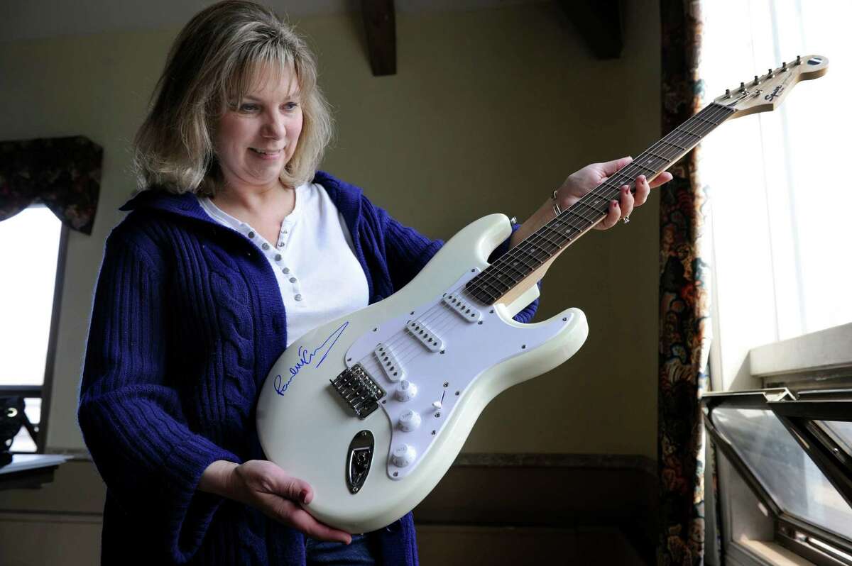 Dawn Fawcett , a co-chair of St. Thomas' Episcopal Church's annual spring auction, holds a guitar signed by Paul McCartney, Tuesday, April 22, 2014. The guitar will be part of the auction Saturday, May 3, 2014 at the Bethel, Conn. church.
