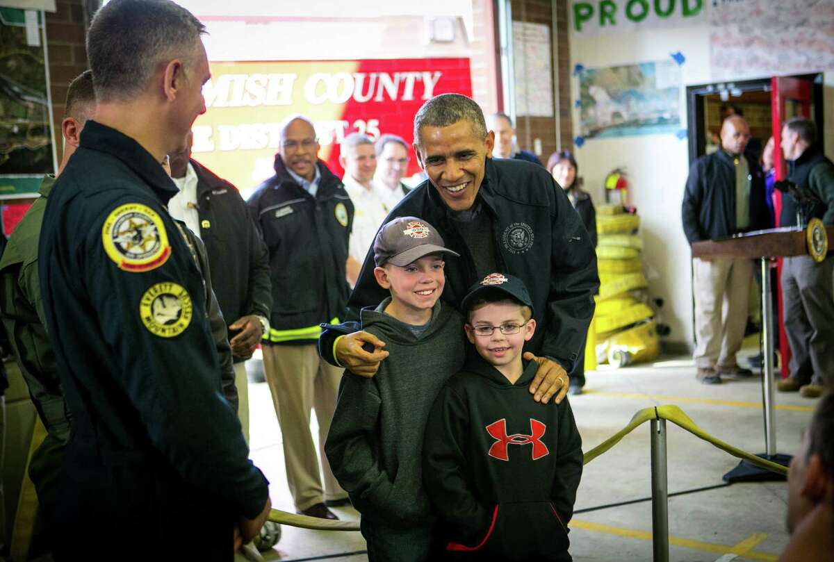 President Barack Obama poses for a photo with Landon Harper, 9, and Levi Harper, 7, sons of Oso Fire Chief Willy Harper, as the president visits the Oso Fire Station. He greeted and spoke with rescuers there, near the scene of last month's deadly Oso mudslide. Photographed on Tuesday, April 22, 2014.