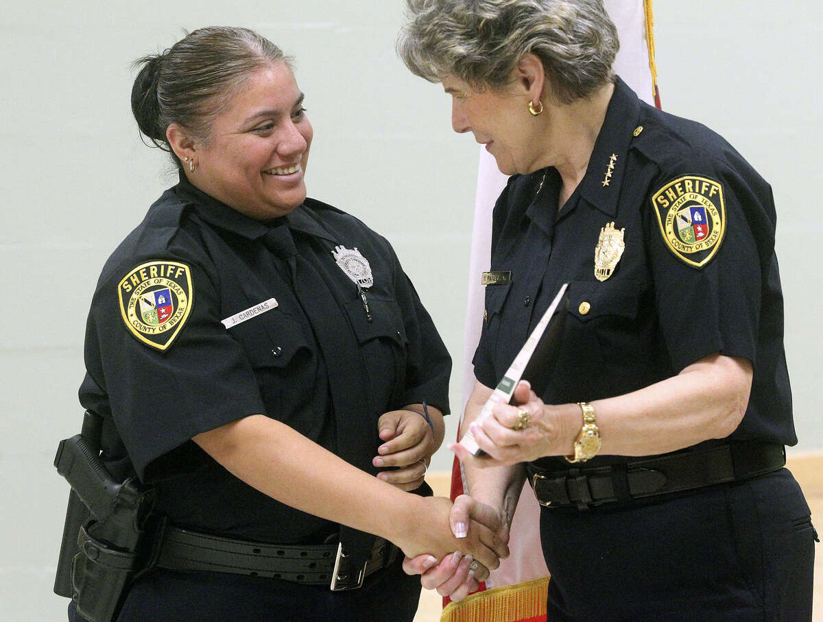 Deputy Jovan Cardenas accepts her certificate from Sheriff Susan Pamerleau as sixteen employees of the Bexar County Jail have earned their professional certification designation from the American Correctional Association on April 22, 2014.