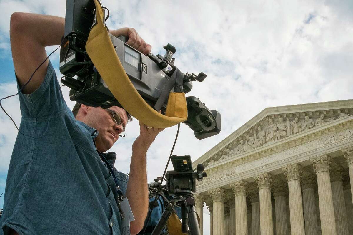 A videojournalist sets up outside of the Supreme Court in Washington, Tuesday, April 22, 2104. The court is hearing oral arguments between Aereo, Inc., an Internet startup company that gives subscribers access to television on their laptops and other portable devices and the over-the-air broadcasters. (AP Photo/J. David Ake)