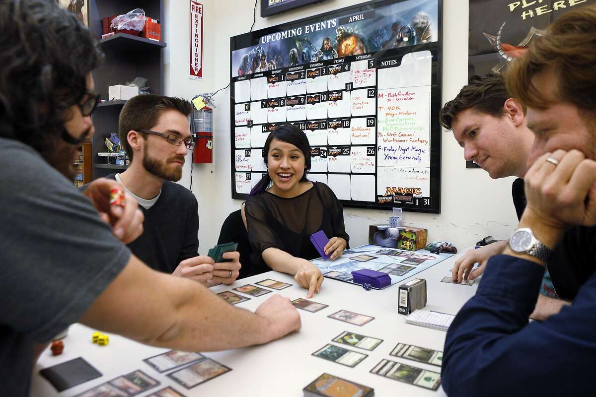 L-R, Mike Escalante, Elliot Morrow, Andi Morrow, Scott Goodenow, and Stewart McMaken play a game of Magic the Gathering at Endgame in Oakland, Calif., on Thursday, April 17, 2014. Endgame, which opened at its current location 10 years ago, sells only board and miniature games and thrives despite not offering video or electronic games. Now, the store is using a Kickstarter campaign to open a cafe that will open next to the main store in several months.