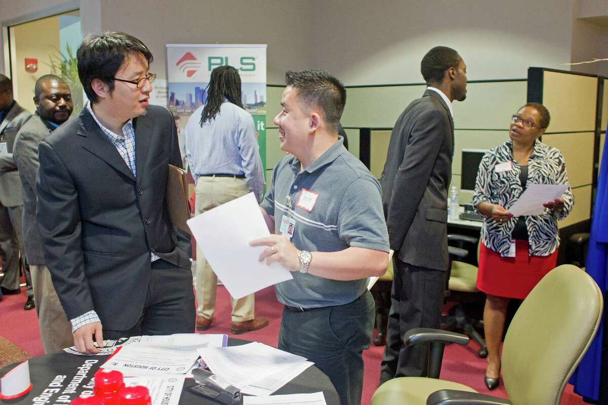 Rick Zhu, left, 30, a PhD candidate in transportation studies at Texas Southern University talks with Bach Le, a senior human resources specialist with the City of Houston during the Texas Southern University Maritime, Transportation and Engineering Career Fair held on campus Wednesday, April 23, 2014, in Houston. "It's important to give me exposure," Zhu said of the career fair. "To get feedback is very important to me and making contacts is very important," he said. ( Johnny Hanson / Houston Chronicle )