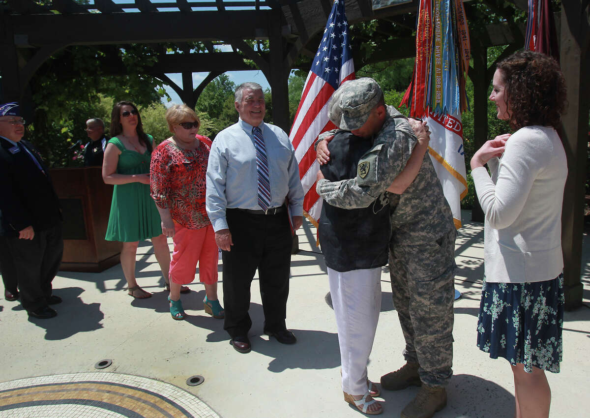 U.S. Army Staff Sergeant Robert T. Drebenstedt (second from right) is congratulated Wednesday April 23, 2014 by his mother Marlys Drebenstedt (black shirt, white pants). Drebenstedt was honored during a ceremony in which he received the Purple Heart medal in the Purple Heart Garden at Joint Base San Antonio-Fort Sam Houston. Drebenstedt was struck August 1, 2012 by an unknown bulk explosive (UBE) while on patrol in Afghanistan. On the right is Sgt. Drebenstedt's wife Lindsey Drebenstedt.