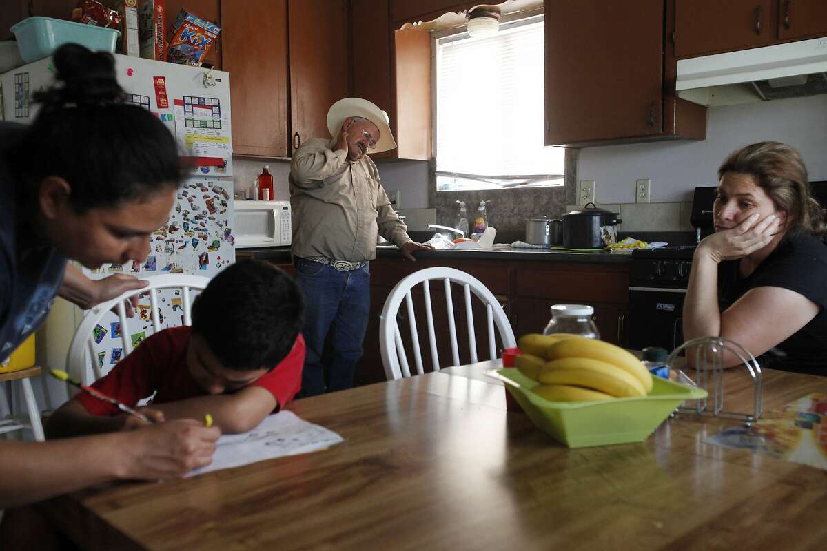 Both unemployed, Jose Pineda Rivas, 61, center, stands in the kitchen with his wife, Maria Callejas, 43, right, as Ruth Fuentes, 32, left, helps her son Jose, 6, with his homework at Fuentes' home April 10, 2014 in Mendota, Calif. Rivas and his wife have been living with the Fuentes' family for four years. Rivas came to the United States in 1988 and was joined by his wife 3 years ago. They left five children behind in El Salvador, who they send money to every month. Both Rivas and his wife work in the fields for their income. Right now neither of them have been able to find steady work and the stress is taking its toll. Rivas has been having trouble sleeping and eating due to a constantly upset stomach and a toothache he cannot afford to repair. "Our biggest worry is that tomorrow there is not going to be a job," said Rivas in Spanish through a translator. The historic drought combined with zero percent water allocation for farmers in the San Joaquin Valley means that many farmers are fallowing fields and many field workers are unemployed. In Mendota, a rural city of about 11,000 people about 35 miles west of Fresno, the jobless rate is 36 percent. Mayor Robert Silva is concerned that this summer it may reach as high as 50 percent. Though there are still precious few jobs this year in the fields, the streets of Mendota, which are usually empty in the middle of the day, are now haunted by people drifting up and down 7th Street, looking for work. Others families have already left to find work elsewhere. The schools have noticed a drop in attendance due to migration, 33 students have left with their families so far this year.