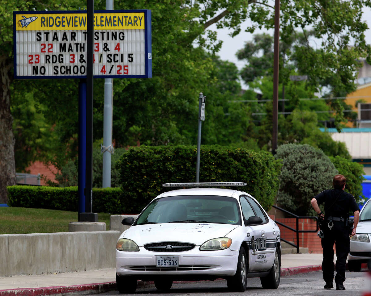 A law enforcement officer walks Thursday April 24, 2014 in the parking lot of Ridgeview Elementary School after a threat was made to an unnamed elementary school. School officials are taking extra precautions to ensure school safety.