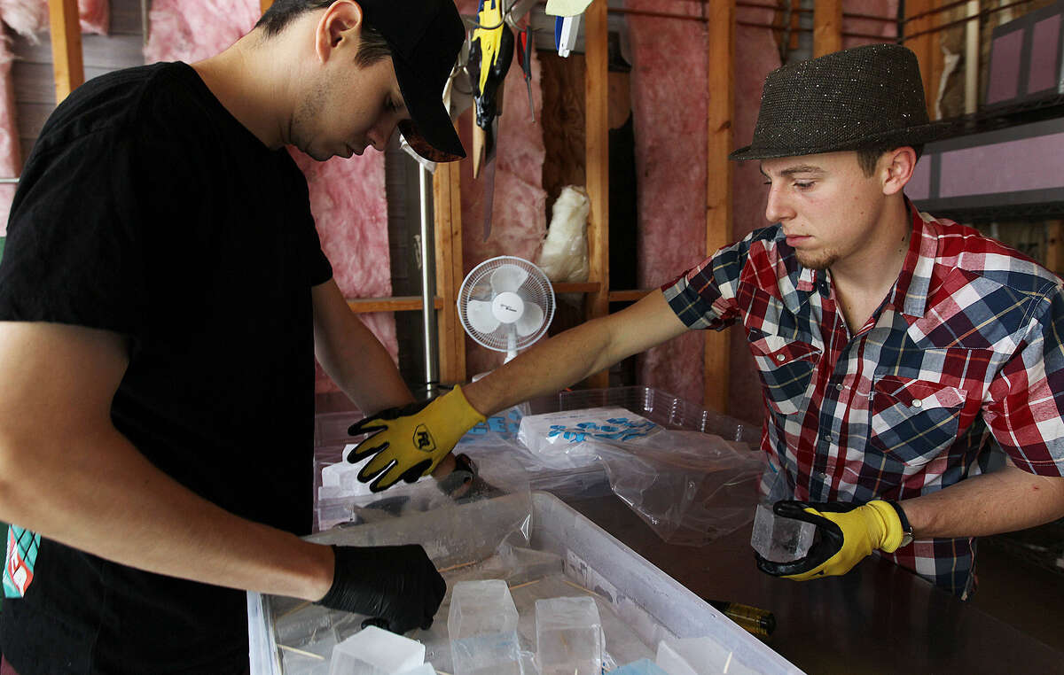 Jake Corney (left) and Andrew Hack pack ice cubes at their business, H&C Ice. They are bringing their experience as bartenders to their business of providing quality ice cubes to bars.