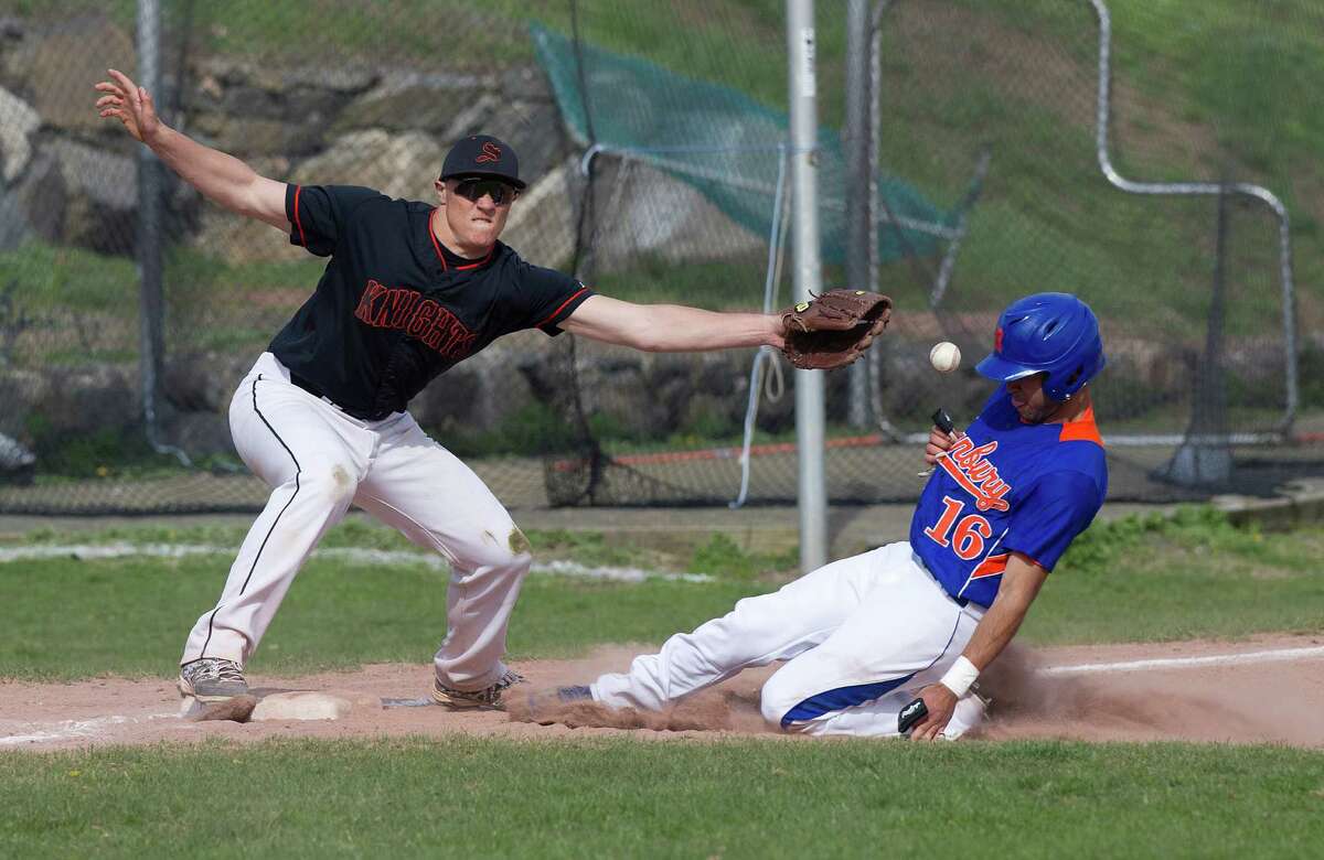 Danbury's Heriberto Rodriguez is safe at third base as Stamford's Jack Rakoczy reaches for the ball during Friday's baseball game at Stamford High School on April 25, 2014.