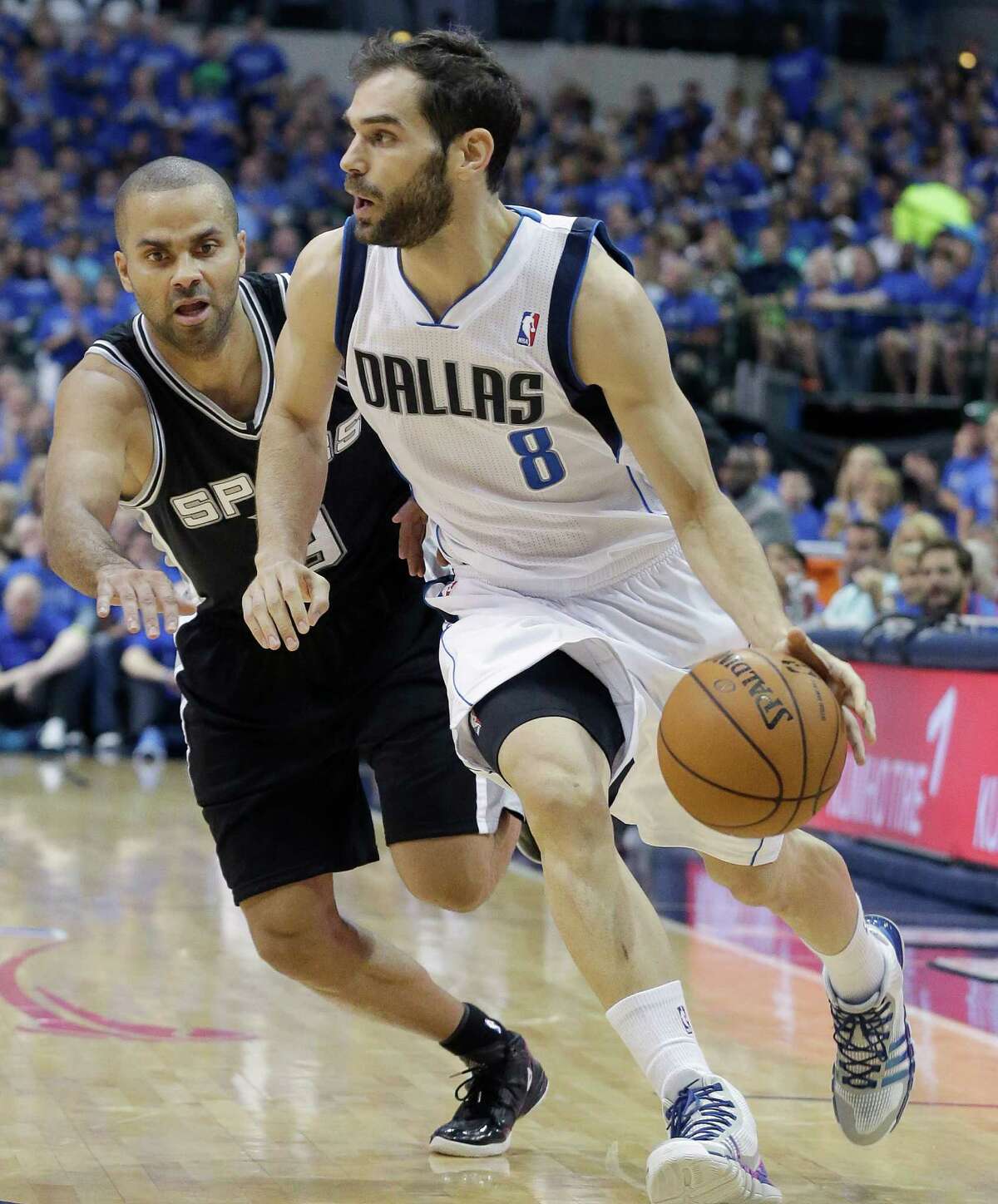 Dallas Mavericks guard Jose Calderon (8) of Spain, drives against San Antonio Spurs guard Tony Parker (9) of France, during the first half in Game 3 in the first round of the NBA basketball playoffs in Dallas, Saturday, April 26, 2014. (AP Photo/LM Otero)