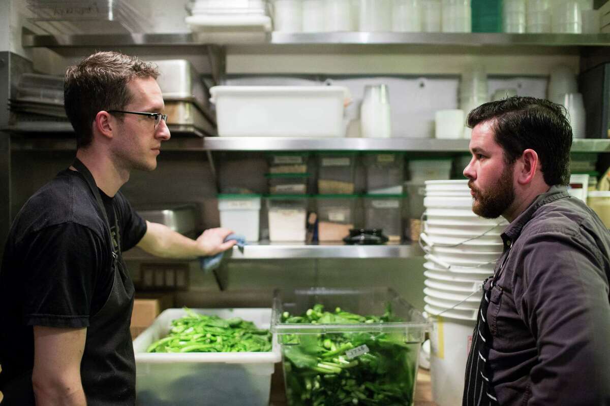 Adam Dorris, chef at Revival Market, right, shares a conversation with sous chef Sam Shire, left, of Bar Tartine, during Dorris' staging time in San Francisco, California Friday, February 21, 2014 Staging, pronounced "stah-zhing," is an internship where chefs work temporarily at a different restaurant to learn new techniques and cuisines.