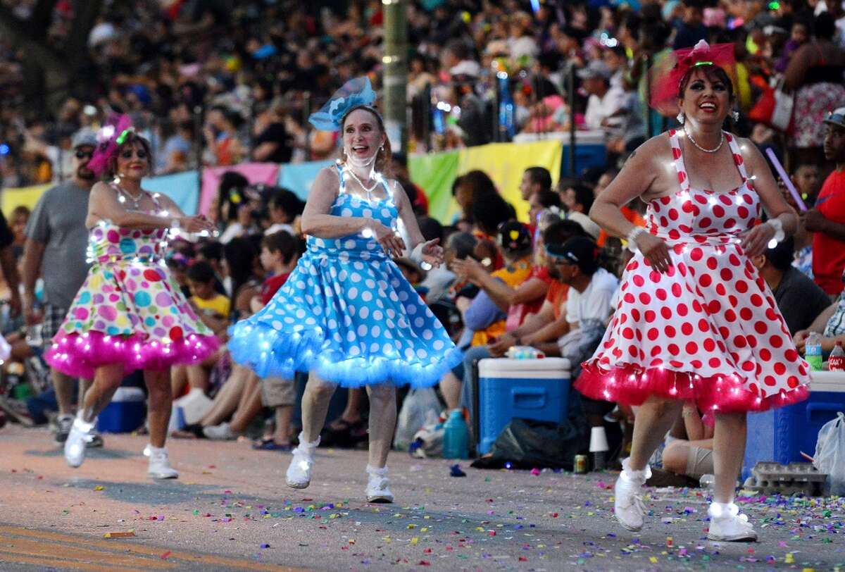 Members of the Charanga's de San Antonio dance along Broadway during the Fiesta Flambeau parade on Saturday, April 26, 2014.