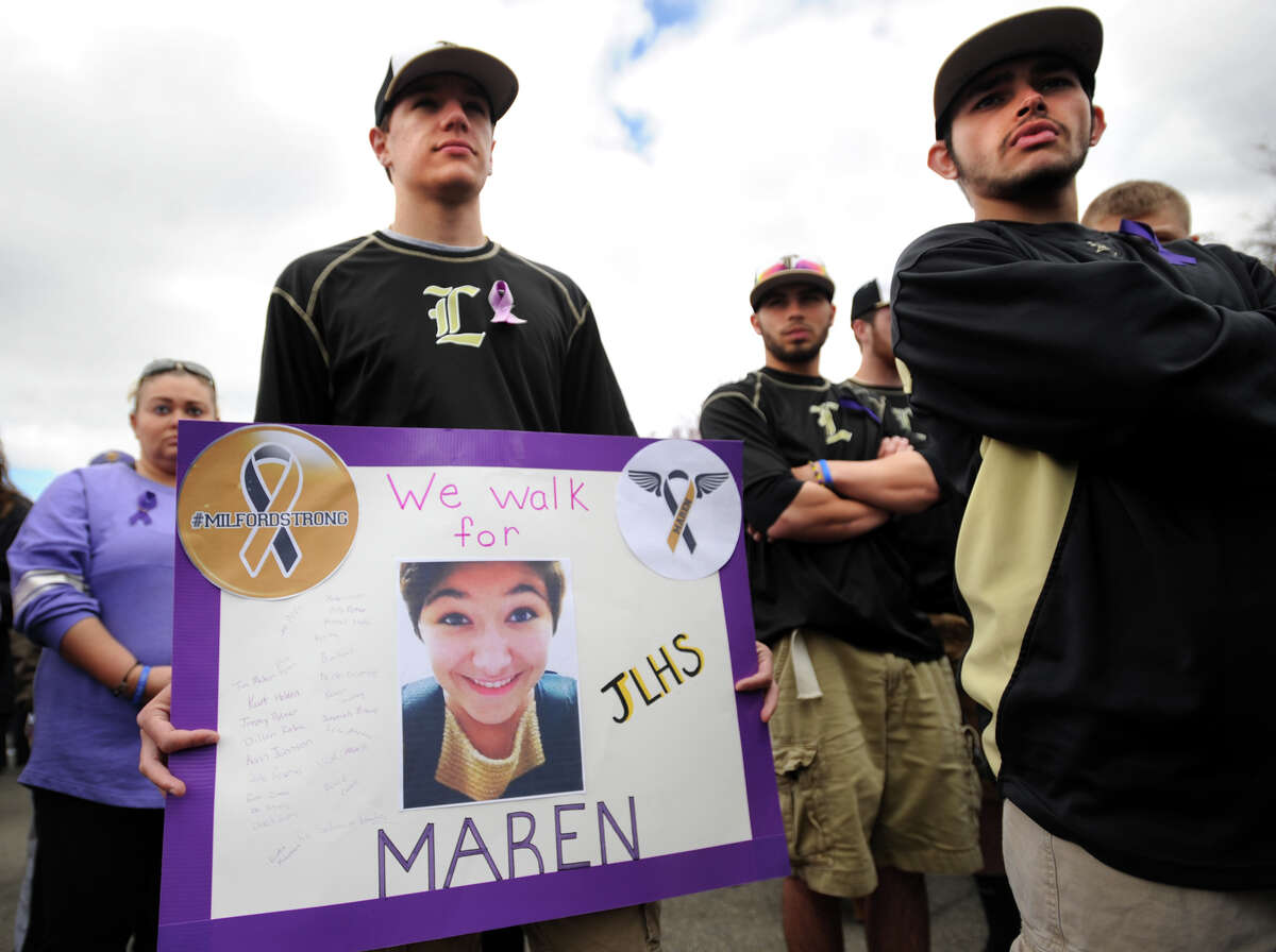 Jonathan Law High School baseball player Kurt Holden holds a sign in memory of classmate Maren Sanchez as he walked with his teammates in her honor at the annual In Your Shoes event at Lisman Landing in downtown Milford, Conn. on Sunday, April 27, 2014.