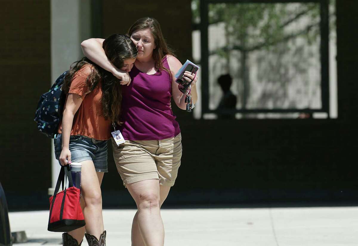 Kim Hunt, right, comforts her daughter Katie Hunt, a 9th grader at Madison, who spent 50 minuets in a supply closet in complete darkness before they were given the all clear. Parents pickup their kids, students at Madison High School, where a student, a gunman, was apprehended for taking weapons to school. Monday, April 28, 2014.