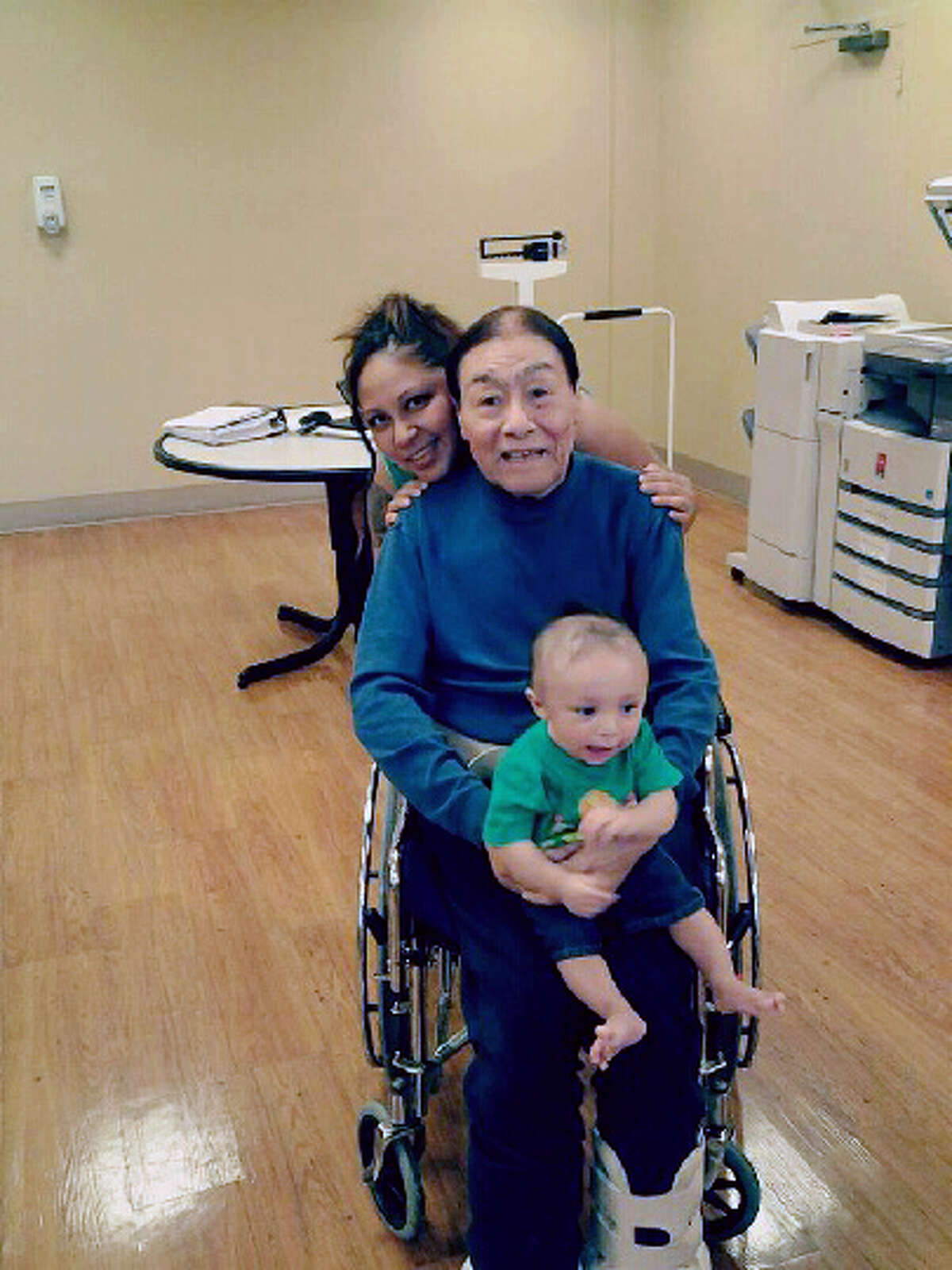 This image provided by Sergio Godoy shows his sister Janet Godoy, rear, grandfather Antonio Acosta and Janet Godoy's son Juan Manuel Gonzalez. Police say a resident of a Houston nursing home will face capital murder charges for using the armrest of his wheelchair to beat two of his roommates, including Acosta, to death. (AP Photo/Sergio Godoy)
