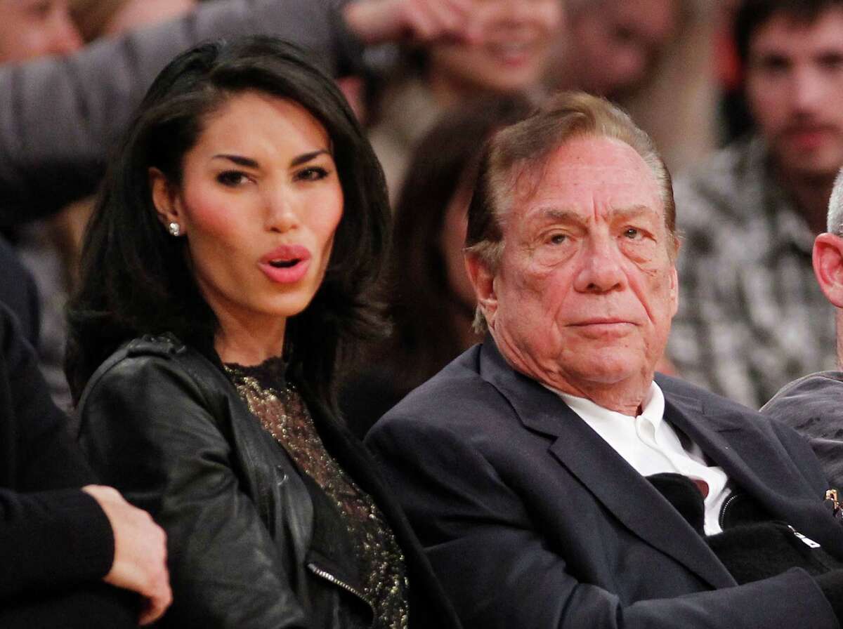 Los Angeles Clippers owner Donald Sterling, right, and V. Stiviano, left, watch the Clippers play the Los Angeles Lakers during an NBA preseason basketball game in Los Angeles on Monday, Dec. 19, 2010. The NBA is investigating a report of an audio recording in which a man purported to be Sterling makes racist remarks while speaking to Stiviano. NBA spokesman Mike Bass said in a statement Saturday, April 26, 2014, that the league is in the process of authenticating the validity of the recording posted on TMZ's website. Bass called the comments "disturbing and offensive." (AP Photo/Danny Moloshok)