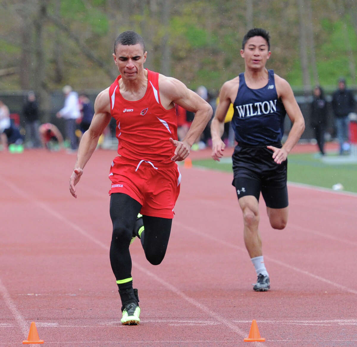 At left, Austin Longi of Greenwich High takes first place in the 100 meter dash beating out Wilton's Marco Agudo, right, during the high school track meet at Greenwich High School, Tuesday, April 29, 2014.