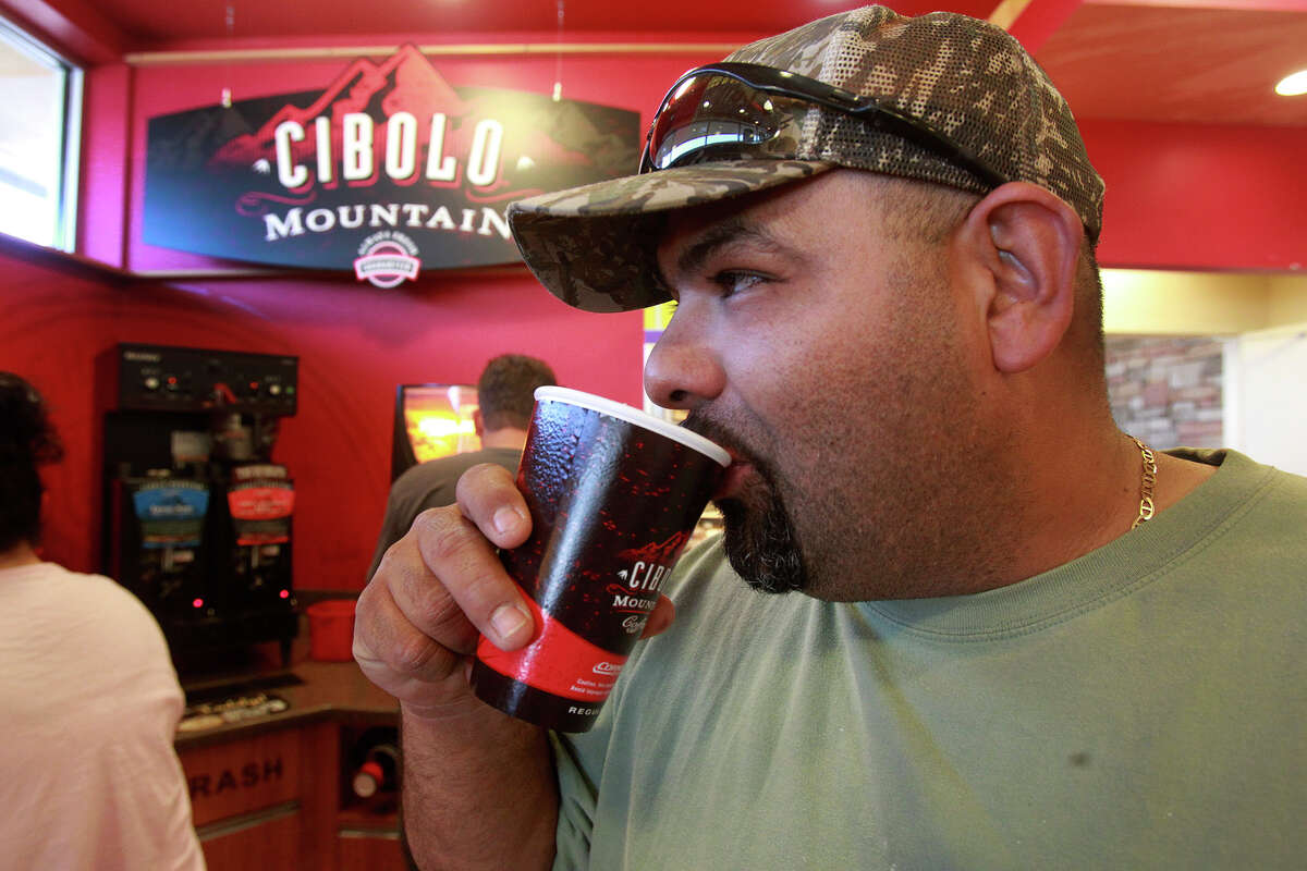 Julio Trevino enjoys a free cup of java Tuesday April 29, 2014 at the Valero at UTSA Blvd. and IH-10. Valero offer free coffee when the Spurs win playoff games and during the NBA Finals.