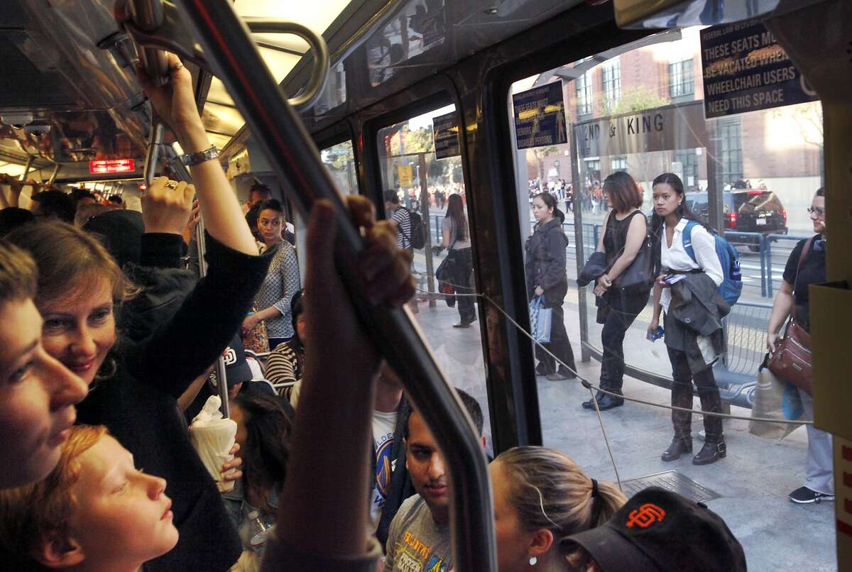 The Muni T line is packed with passengers including Angelika Ryan, upper left, and her two sons Dmitri,10, lower left, and Gennadi, 14, far left, as it arrives at the ballpark April 29, 2014 in San Francisco, Calif. Ryan, who takes her family to Giants games via the T line a few times a year says it's always this packed and it's worse on the weekends.