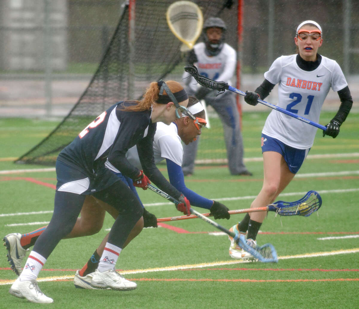 New Fairfield's Danielle Hanley, #22, and Danbury's Najmah James, #2, battle over the ball during the New Fairfield at Danbury High School girls lacrosse game, in Danbury, Conn, on Wednesday, April 30, 2014. Behind them are Danbury's Brittany Kenyon, #21, and goalie Ketsia Lefranc, 324.