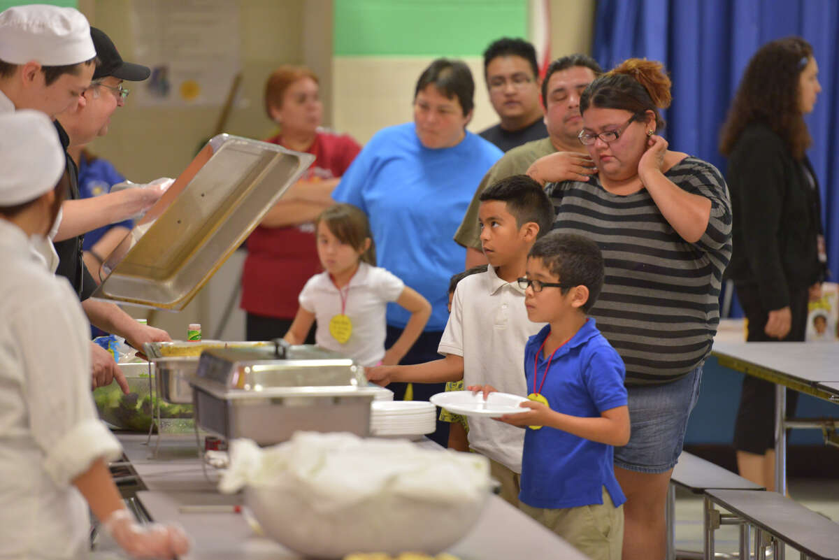 Culinary Arts students from Memorial High School serve dinner to the participants in the LaCena Literacy program at Loma Park elementary School recently.