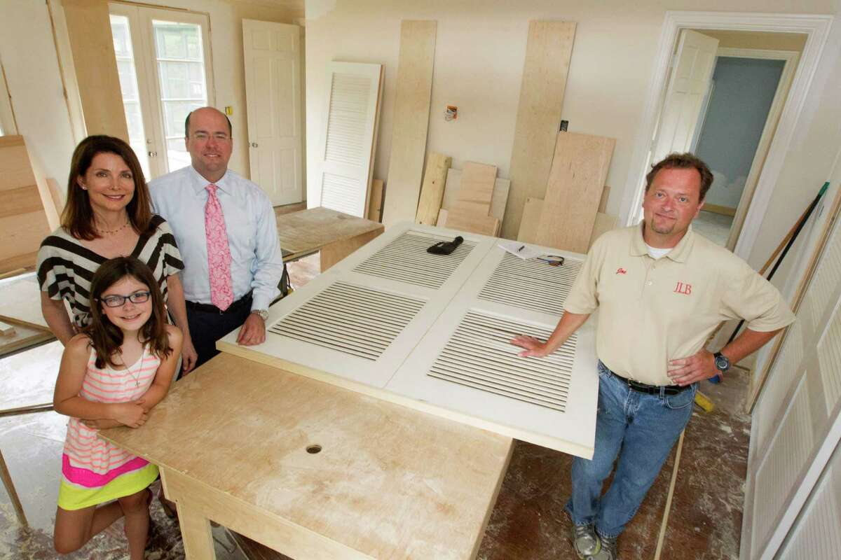 Katherine DeLaune and Lee Steely along their daughter Ava, 9, pose for a portrait with their builder Joe Bielamowiez, right, on Monday, April 21, 2014, in Houston. Their upper Kirby home is going through a major renovation. ( J. Patric Schneider / For the Chronicle )