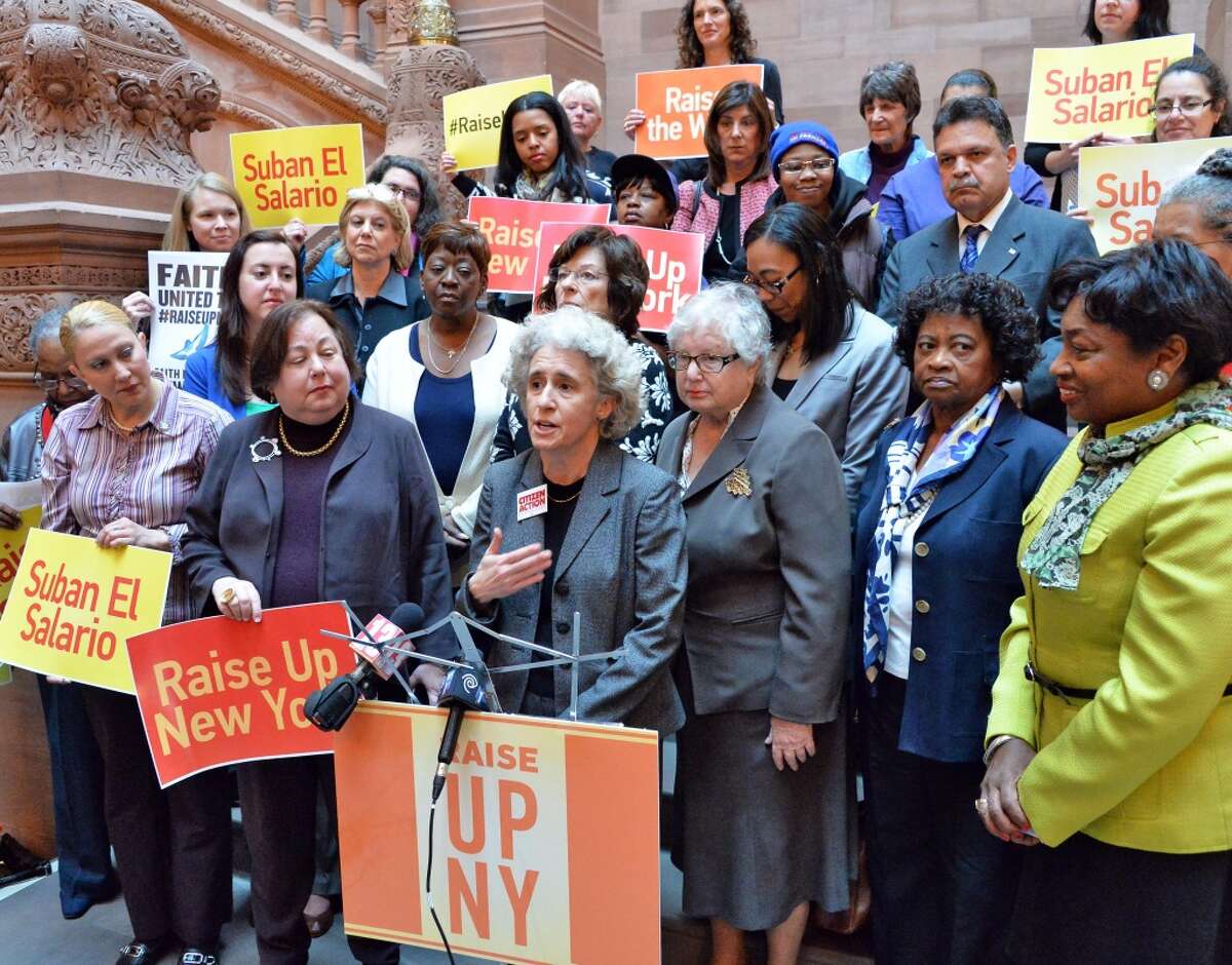 Karen Scharff, center, of Citizens Action of New York joins a group of prominent women leaders to demand support for legislation allowing cities and counties to raise wages above the state's minimum wage Wednesday April 30, 2014, during a demonstration at the Capitol in Albany, N.Y. (John Carl D'Annibale / Times Union)