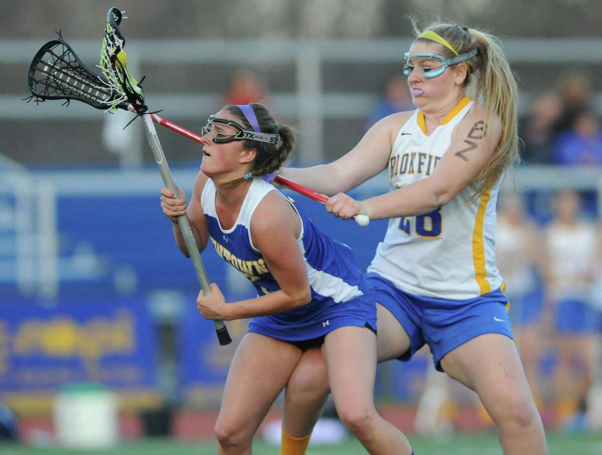 Newtown's Carley Ferris, left, gets fouled by Brookfield's Stephanie Hunt in Brookfield's 9-7 win over Newtown in the high school girls lacrosse game at Brookfield High School in Brookfield, Conn. Thursday, May 1, 2014.