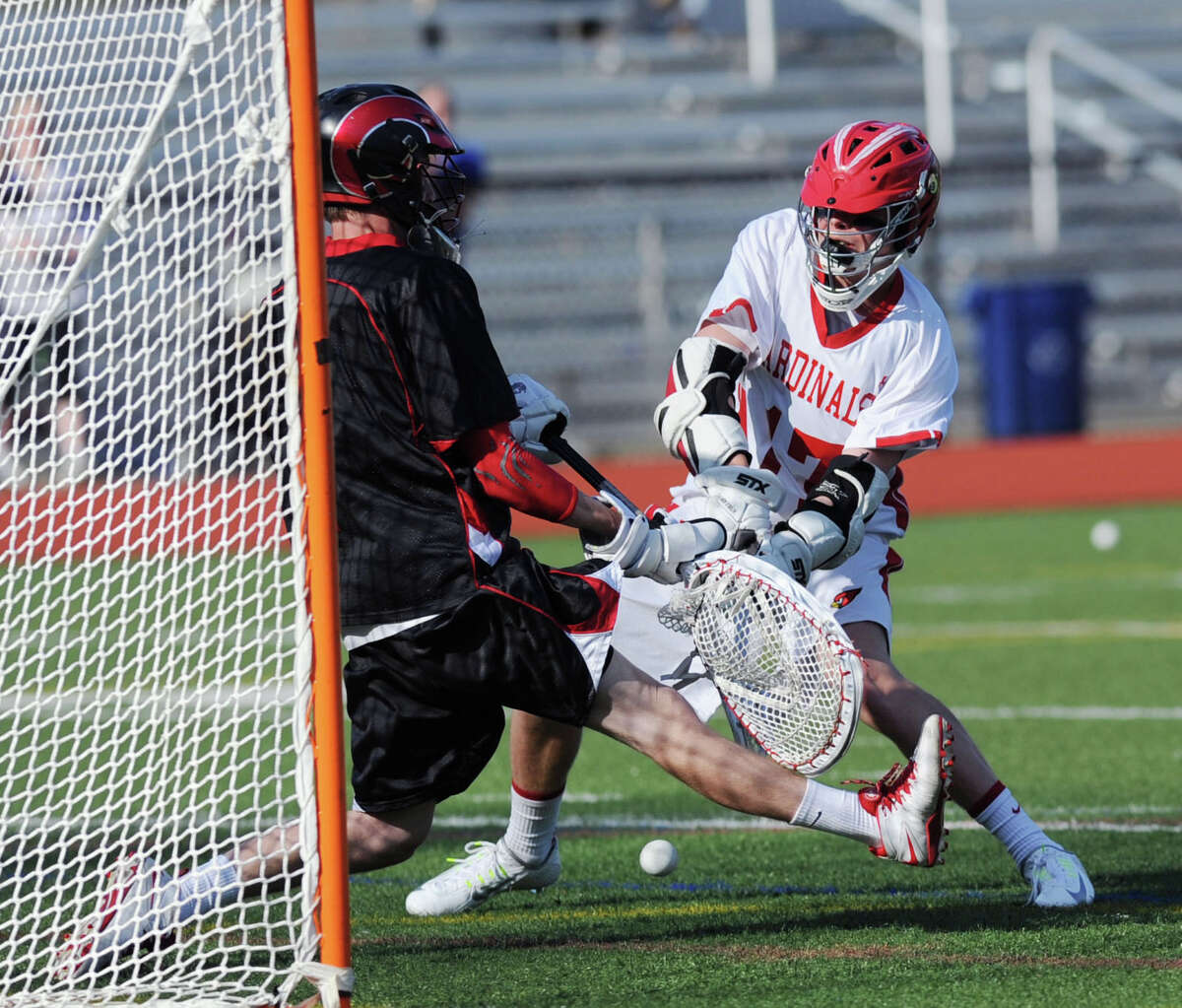 Bobby Goggin, right, of Greenwich, goes low with a shot that New Canaan goalie Trent Nader was able to block with his back leg during the high school lacrosse match between Greenwich High School and New Canaan High School at Greenwich, Thursday, May 1, 2014. Greenwich defeated New Canaan, 10-8.