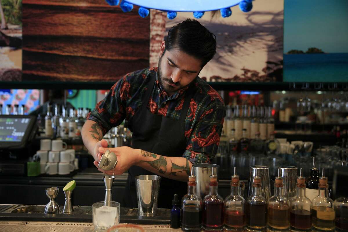 Leon Vazquez, bartender, squeezes a wedge of lime as he makes a regular margarita at Lol— restaurant on Friday, May 2, 2014 in San Francisco, Calif.