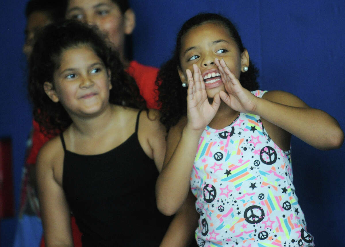 Leilani Perez, 7, left, and Chantal Vizcarrondo, 8, both of Bridgeport, cherr on their teammates during a relay race in the gym of the Orcutt Boys & Girls Club at 102 Park Street in Bridgeport, Conn. on Thursday, July 11, 2013. The club, which lacks air conditioning, was constructed in 1930.