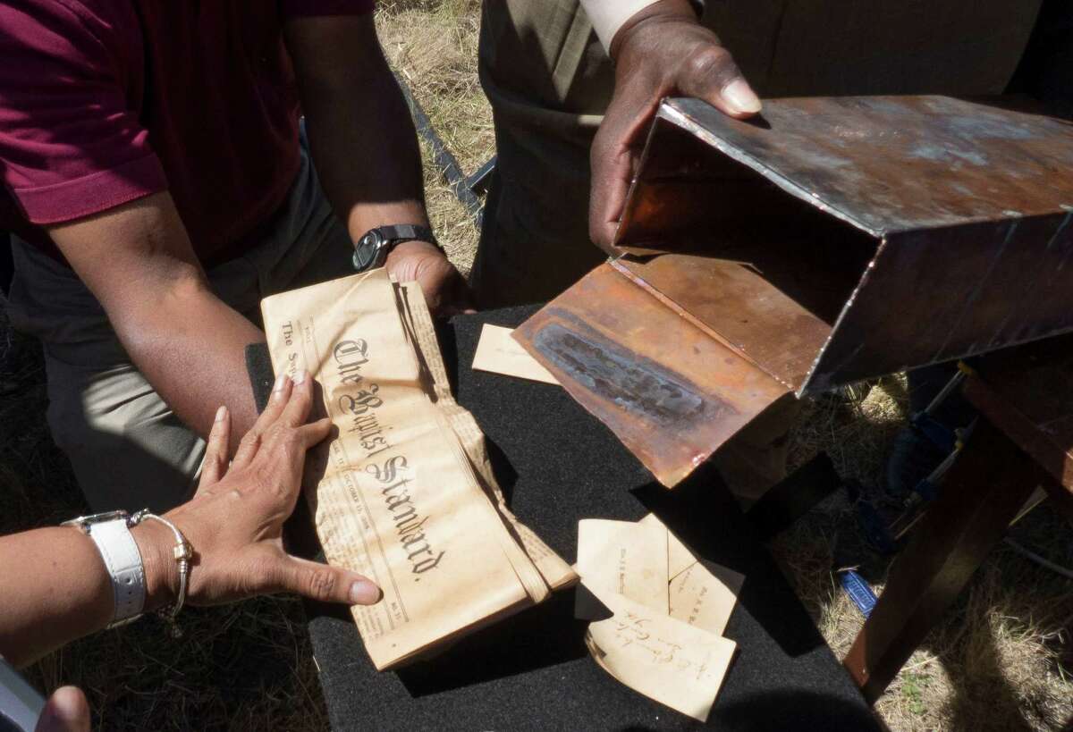 The contents of a time capsule found in the burned remains of the old Childress Memorial Church of God in Christ in Dignowity Hill are poured out after it was opened during the groundbreaking ceremony for the church's new location on Binz-Engelman Road on Saturday, May 3, 2014.