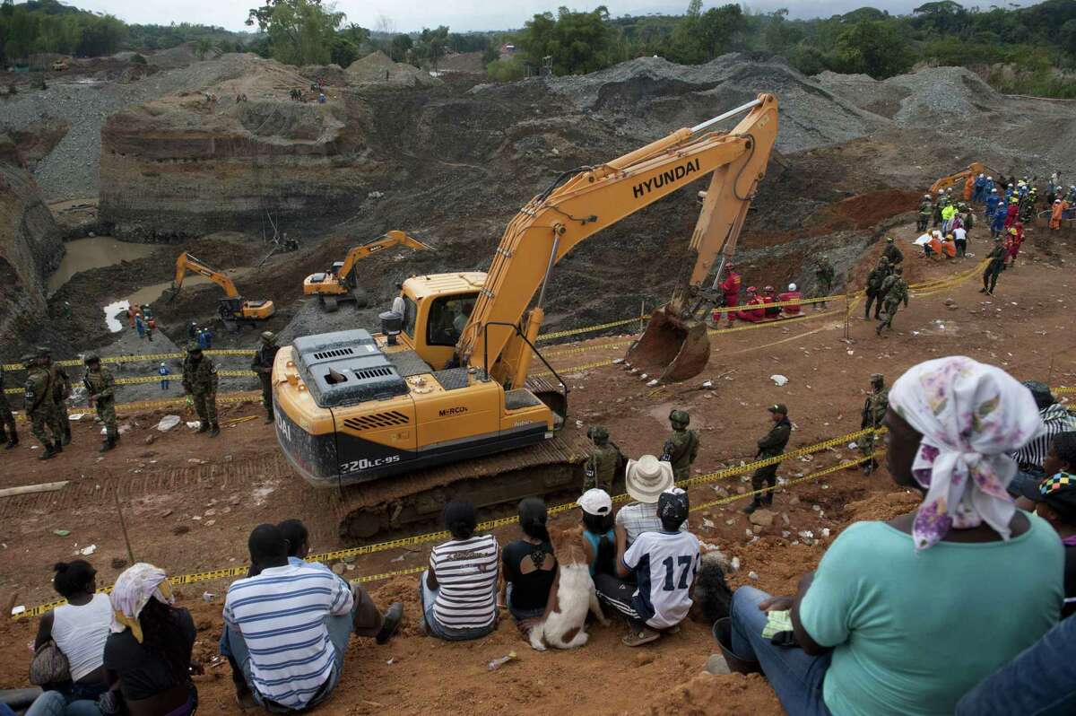 Rescue workers try to remove sludge to search for the 13 men buried when a gold mine collapsed in southwest Colombia on Wednesday night.