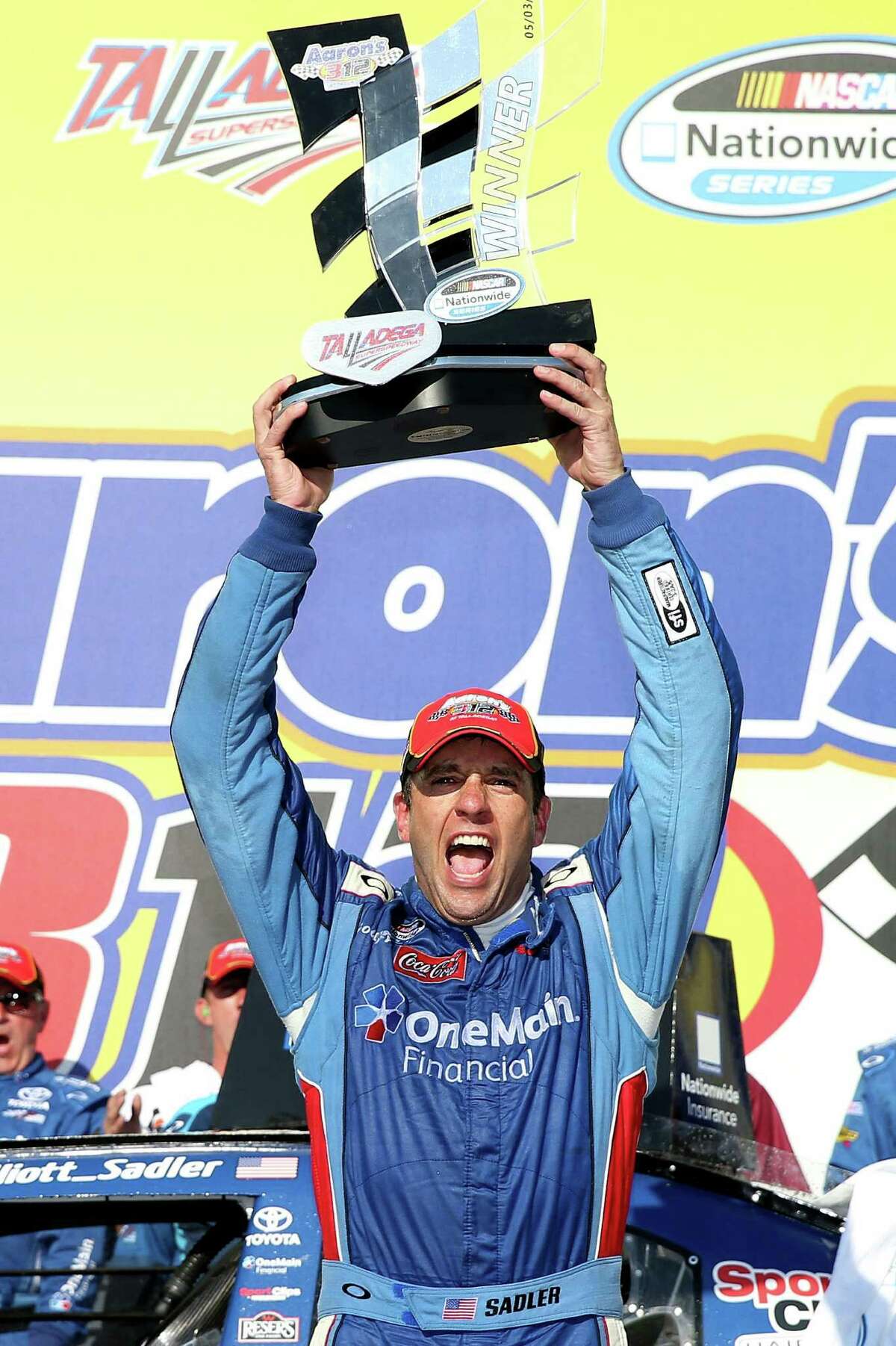 Elliott Sadler rejoices with his trophy after winning a three-lap shootout in Saturday's Nationwide Series race.