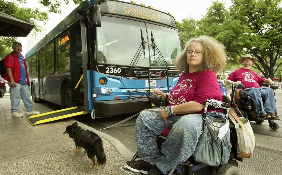 Stephanie Thomas and her support dog, Boots Templeton, along with Gene Rodgers (right) board a bus to attend a rights protest in Austin in this file photo. Austin is very dog-friendly, which probably helped them to be named DogTown USA 2014 by Dog Fancy magazine.