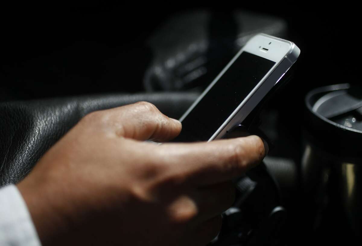 An Uber driver plugs an address into his phone before driving a passenger to her destination on May 2. Background checks for Uber drivers have recently come under fire.