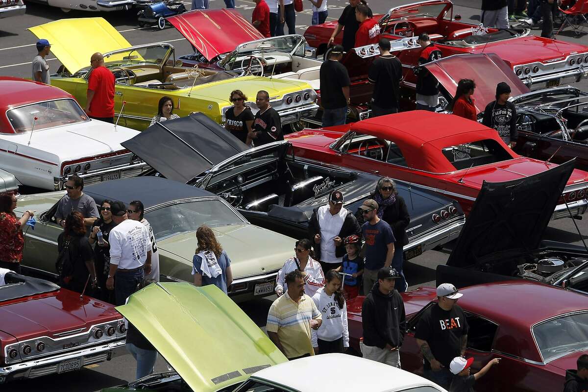 People look at cars on display during a low rider car show benefit fundraiser for John O'Connell High School in the school's parking lot in San Francisco, CA, Sunday May 4, 2014.