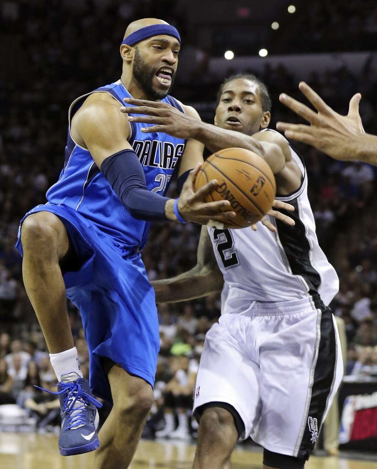 Dallas Mavericks' Vince Carter passes around San Antonio Spurs' Kawhi Leonard during first half action of Game 7 in the first round of the Western Conference playoffs Sunday May 4, 2014 at the AT&T Center.