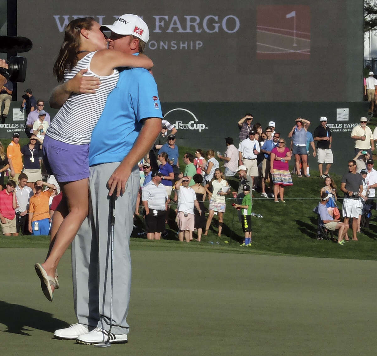 Sara Holmes gives her husband, J.B., a big kiss after he finished off his victory at the Wells Fargo Championship. Holmes is back on the PGA Tour after two brain surgeries, an elbow operation and a broken ankle. The victory was worth $1,242,000.