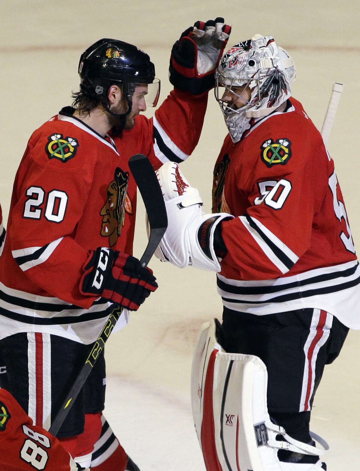 Chicago's Brandon Saad (left), who scored two goals, and Corey Crawford, who made 18 saves, enjoy their Game 2 win.