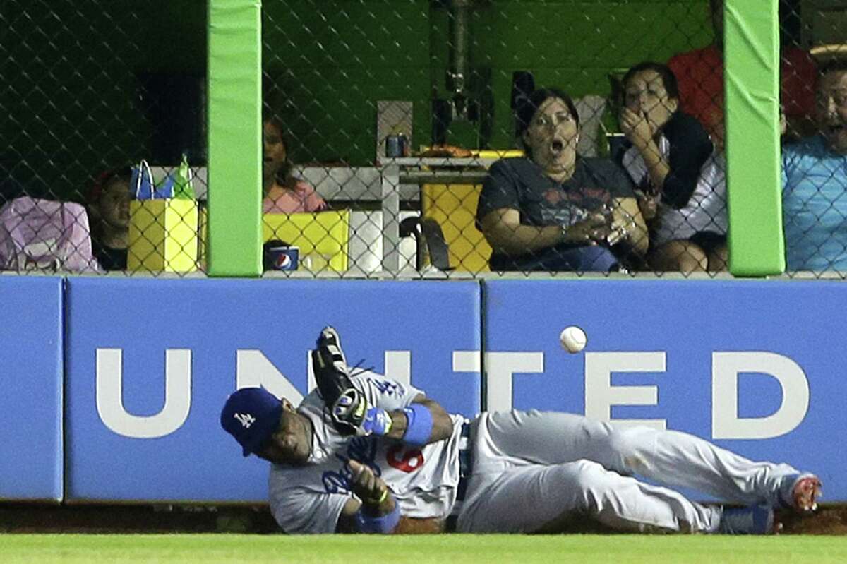L.A.'s Yasiel Puig is on the ground after he couldn't catch a game-winning hit by Miami's Jeff Baker.