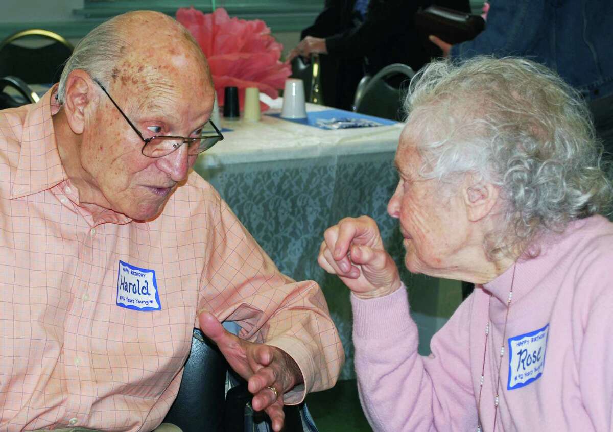 Harold Mayer, who will be 95 in May, and Rose Prasse, 92, greet each other at the start of the New Milford Senior Center's party honoring residents who are aged 90 and older. April 11, 2014.