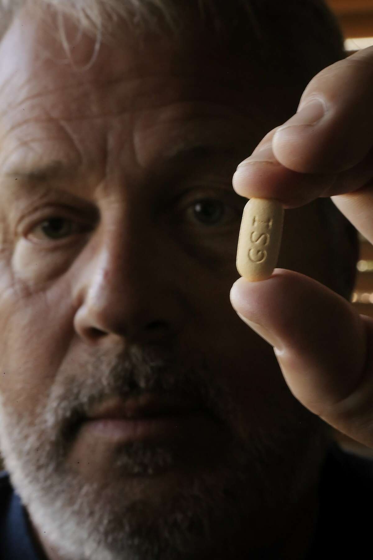 Scott Barnes holds a pill of Sovaldi in his San Luis Obispo, Calif., home on Wednesday, April 30, 2014. Barnes is a Vietnam War army veteran who suspects he caught hepatitis C (before it was known by that name) toward the end of the war (1973) but wasn't officially diagnosed until the 2000s. He was able to convince his VA doctors to help him get on a regimen of Sovaldi, a drug developed by Gilead Sciences, which is hailed as a cure for hepatitis C. He has stage IV hep C, and sees this treatment as his last chance.