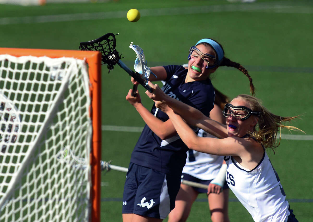 Wilton's Annie Cornbrooks tries to score a goal as Staples' Nicole Williams blocks, during girls lacrosse action in Westport, Conn. on Tuesday May 6, 2014.